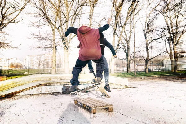 Unga skateboardåkare hoppa på en ramp utomhus — Stockfoto