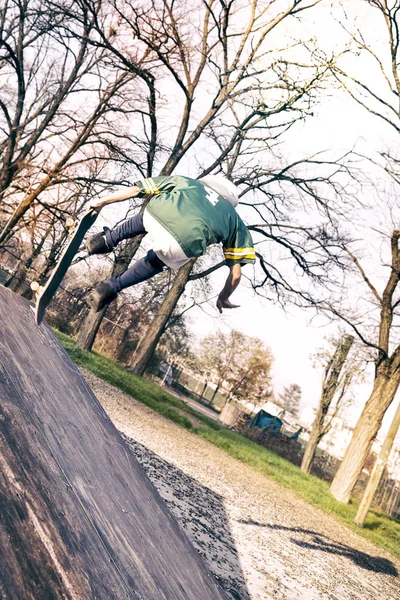 Jeune skateboarder sautant sur une rampe en plein air — Photo