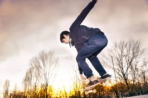 Giovane skateboarder saltare su una rampa esterna — Foto Stock