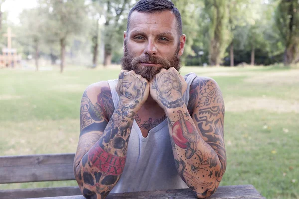 Portrait d'un homme barbu avec des coudes sur la table dans le parc — Photo