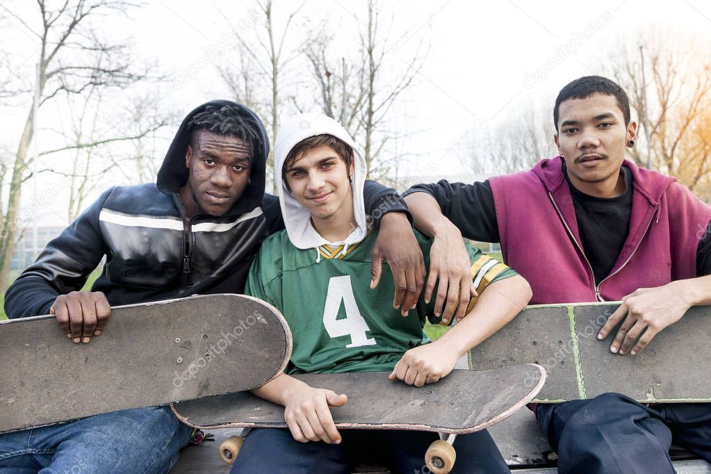 group of young adults sitting on a ramp with skateboard