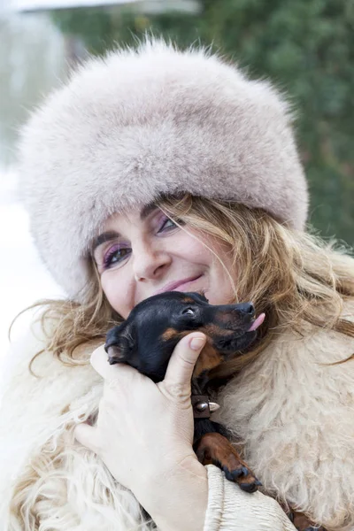 Ładna pani przytulić jej piesek w okresie zimowym — Zdjęcie stockowe