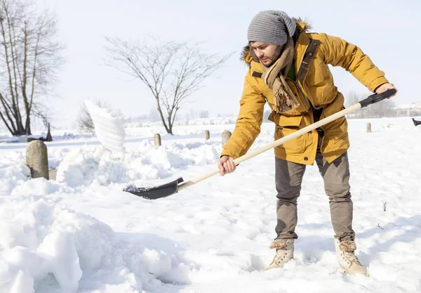 Jonge man sneeuwschuiven in het land — Stockfoto