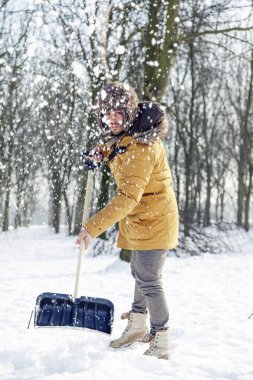 genç adam yakınındaki küçük bir ahşap kar kürekle
