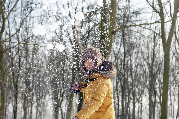 Mladý muž odhazování sněhu u lesíka — Stock fotografie