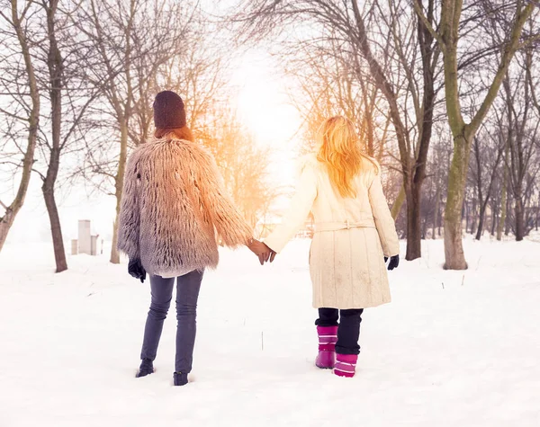 Mutter und Tochter im Schnee an der Hand — Stockfoto