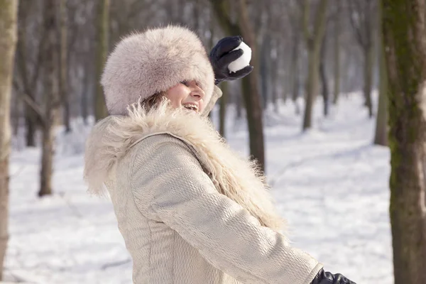 Vacker dam drar snöbollar i skogen — Stockfoto