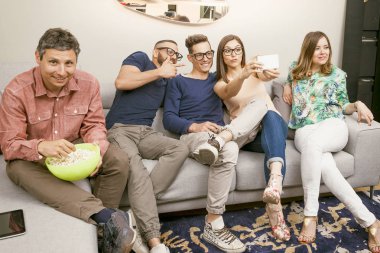 arkadaşlar kanepede grup bir selfie komik bir biçimde alır.