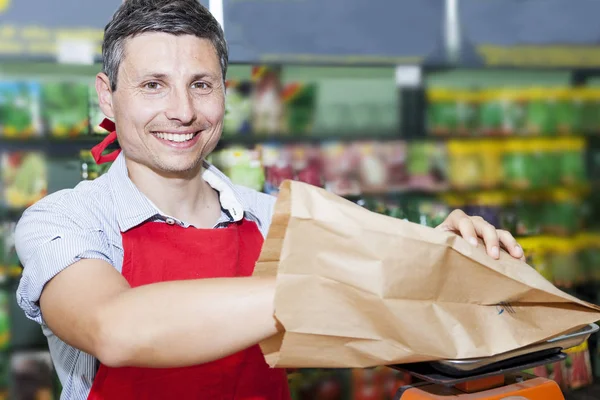 Venditore sorridente di semi per giardinieri nel suo negozio — Foto Stock