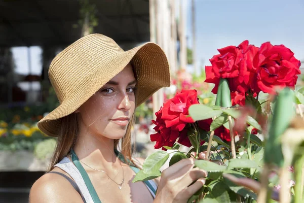 young flower seller takes care of her red roses