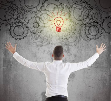 dişli sembolleri duvara boyalı genç işadamı bakar