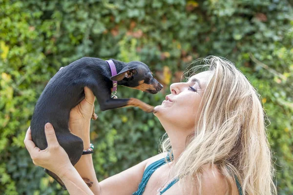 Привлекательная женщина играет со своей собакой на открытом воздухе — стоковое фото