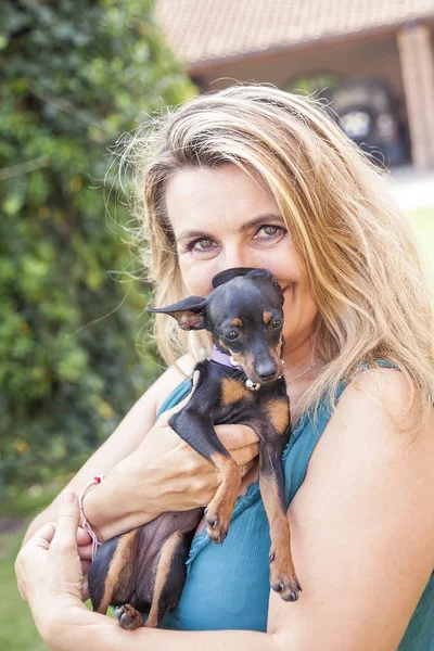 魅力的な女性は彼女の犬を屋外で遊ぶ — ストック写真