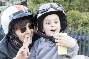 Baba ve oğul motosikletçiler bir selfie üstünde belgili tanımlık yol al.