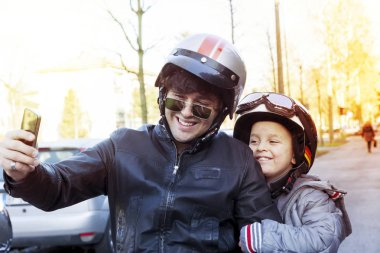 Baba ve oğul motosikletçiler bir selfie üstünde belgili tanımlık yol al.
