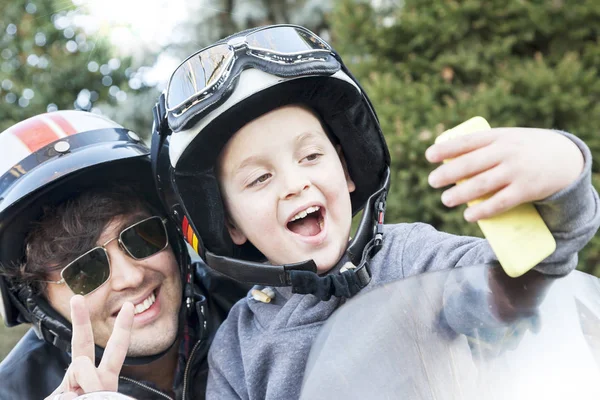 Pai e filho motociclistas tirar uma selfie na estrada — Fotografia de Stock