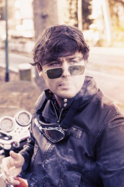 bir sigara rahatlatıcı genç motorcu