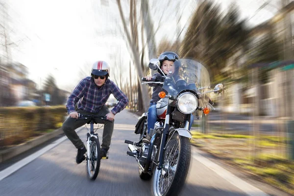 Adultos jovens simulam uma corrida simulada entre moto e bicicleta — Fotografia de Stock