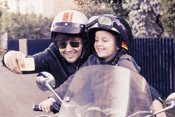 Motociclistas pai e filho tirar uma selfie na estrada — Fotografia de Stock