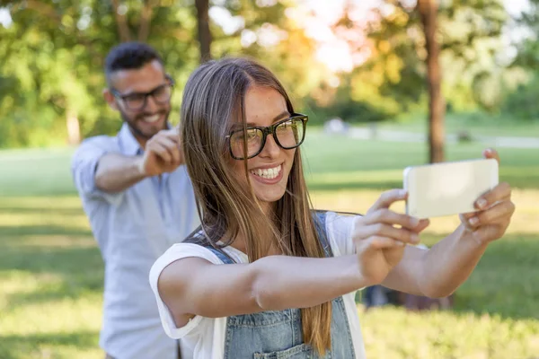若い大人の素敵なカップルが公園で、selfie を取る — ストック写真
