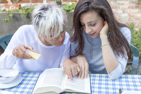 Ładny Mama i Córka, czytanie książki, jedząc śniadanie ou — Zdjęcie stockowe