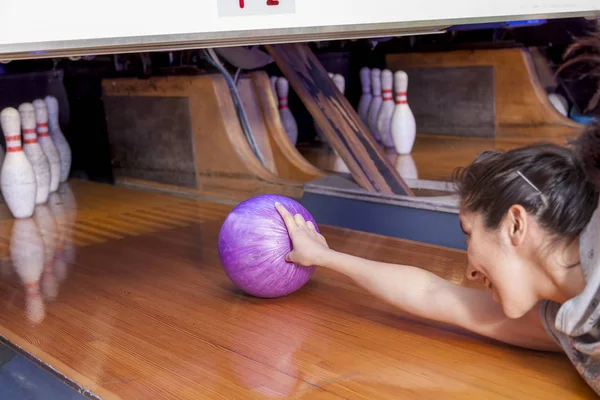 Ung kvinna glida ner en bowlinghall — Stockfoto