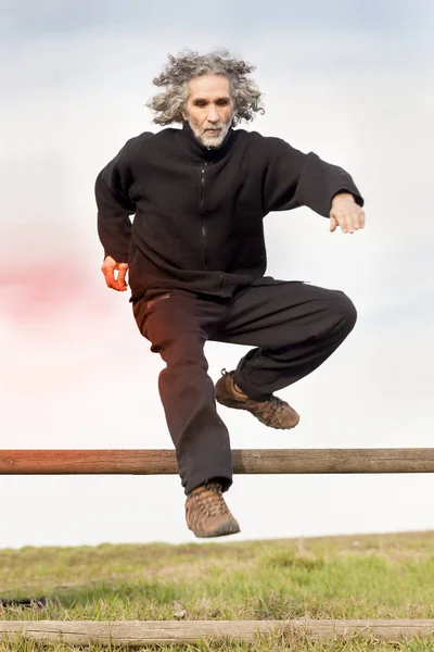 Deportista adulto corriendo y saltando obstáculos naturales al aire libre — Foto de Stock