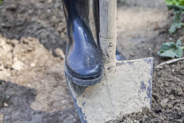 woman digging in the garden with black boots