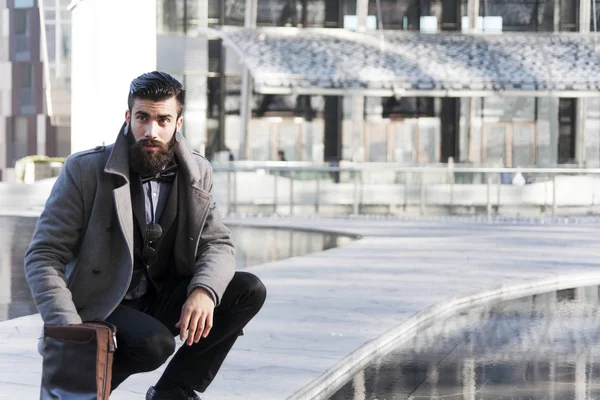 Young hipster businessman consults his laptop in the heart of ci — Stock Photo, Image