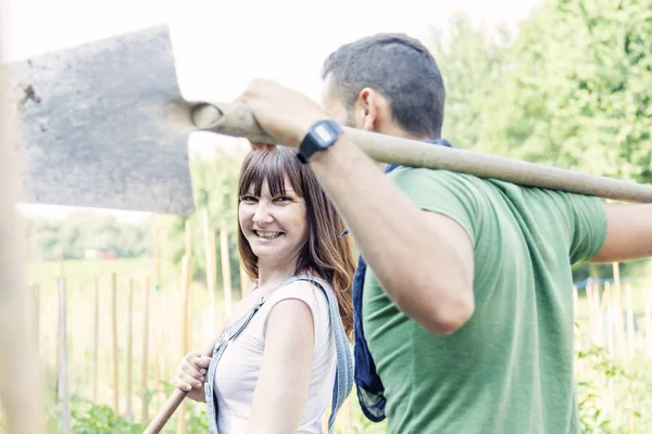 Jovem casal ir para o trabalho em seu jardim — Fotografia de Stock