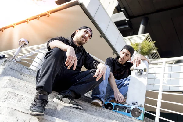 Dvě mladé skateboardista relaxovat na okraji schody — Stock fotografie