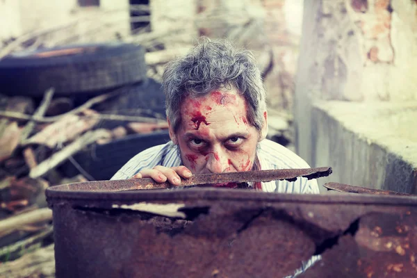 Aterrador hombre zombi sangriento en las ruinas de una antigua casa — Foto de Stock