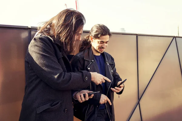 Glada unga vuxna skicka meddelanden med din smartphone — Stockfoto