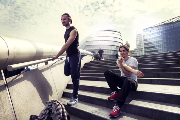 Atletische jonge volwassenen zijn uitrekken zich tegenover het stadhuis o — Stockfoto