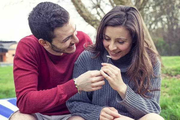 Lover boy gives a daisy to her girlfriend in the park — Stock Photo, Image