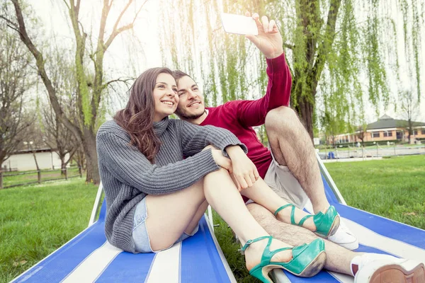 Ωραίο ζευγάρι φίλους παίρνει μια selfie χαλαρώνοντας στις ξαπλώστρες έξω — Φωτογραφία Αρχείου