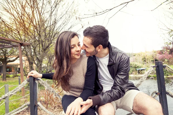 Beau couple de copains embrasse et embrasse sur un pont en bois — Photo