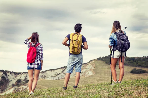 Skupina mladých turistů k obzoru přešla mounta — Stock fotografie