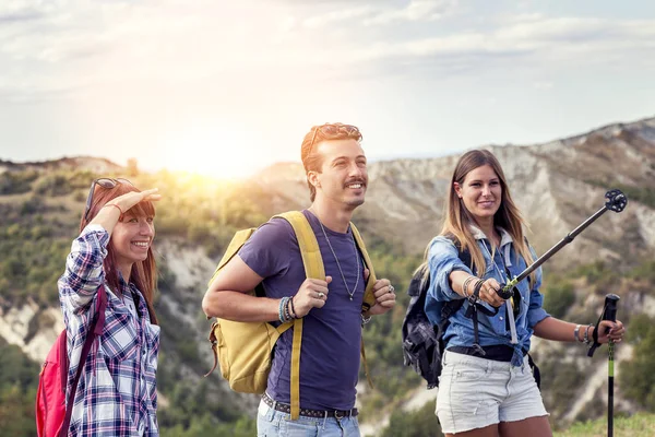 Grupo de jóvenes excursionistas caminando hacia el horizonte sobre la montaña — Foto de Stock