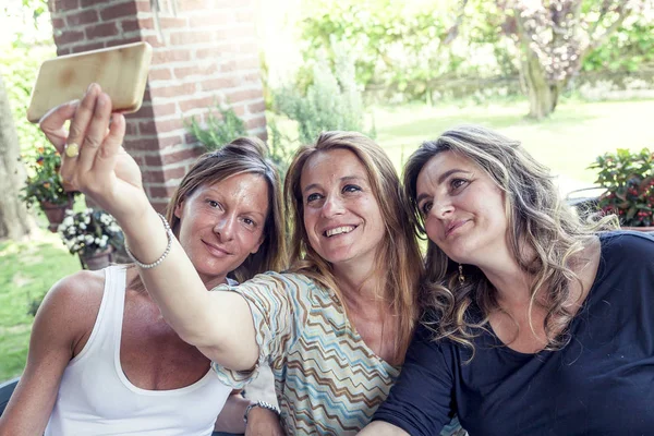 Tre donne piuttosto mature si fanno un selfie in campagna — Foto Stock