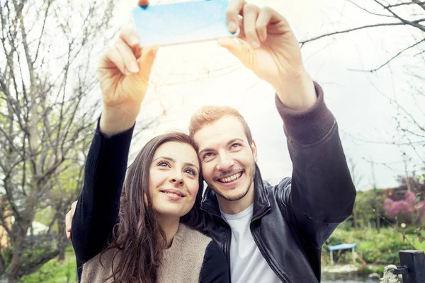 Ωραίο ζευγάρι φίλους παίρνει μια selfie χαλάρωση στο πάρκο outdo — Φωτογραφία Αρχείου