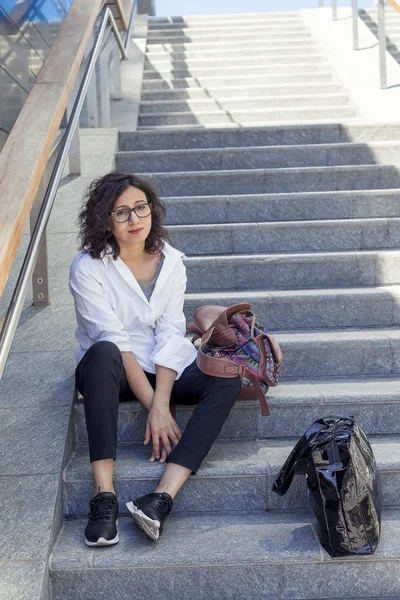 Bella ragazza seduta su una scala al centro di un capo europeo — Foto Stock