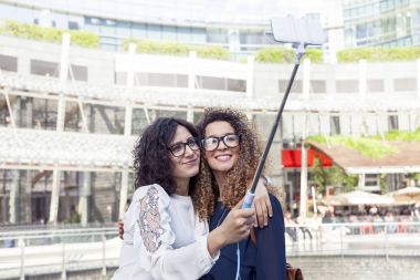 iki güzel kız gülümseyerek bir selfie smartphone ile alır