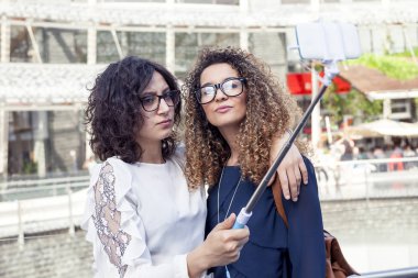 iki güzel kız gülümseyerek bir selfie smartphone ile alır