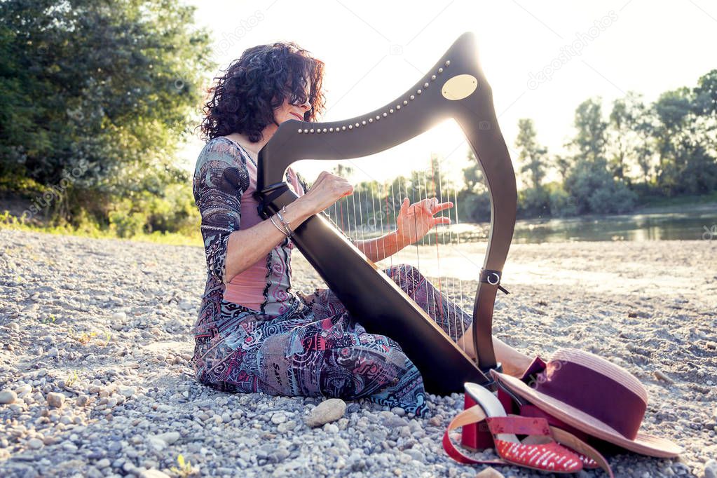 beautiful curly hair woman playing the harp