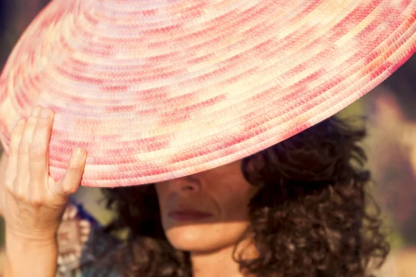 Beautiful woman plays with her straw hat — Stock Photo, Image