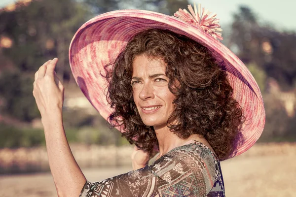 Beautiful woman plays with her straw hat — Stock Photo, Image