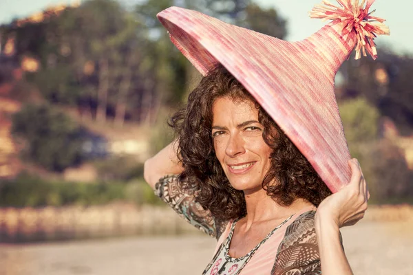 Beautiful woman plays with her straw hat — Stock Photo, Image