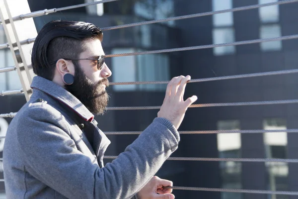 Jovem hipster empresário olhar para o tráfego em uma ponte de ferro — Fotografia de Stock