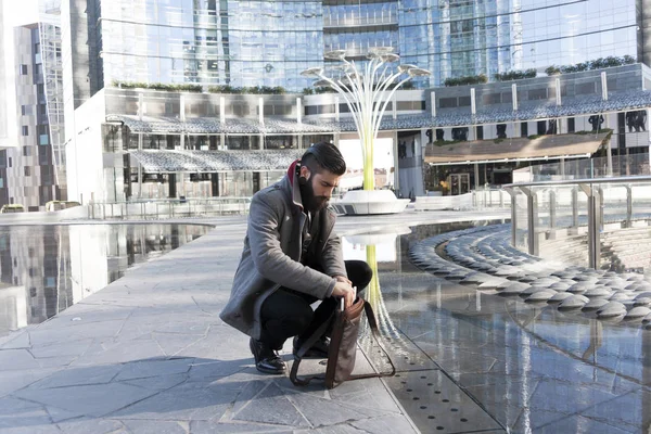 Young hipster businessman consults his laptop in the heart of ci — Stock Photo, Image